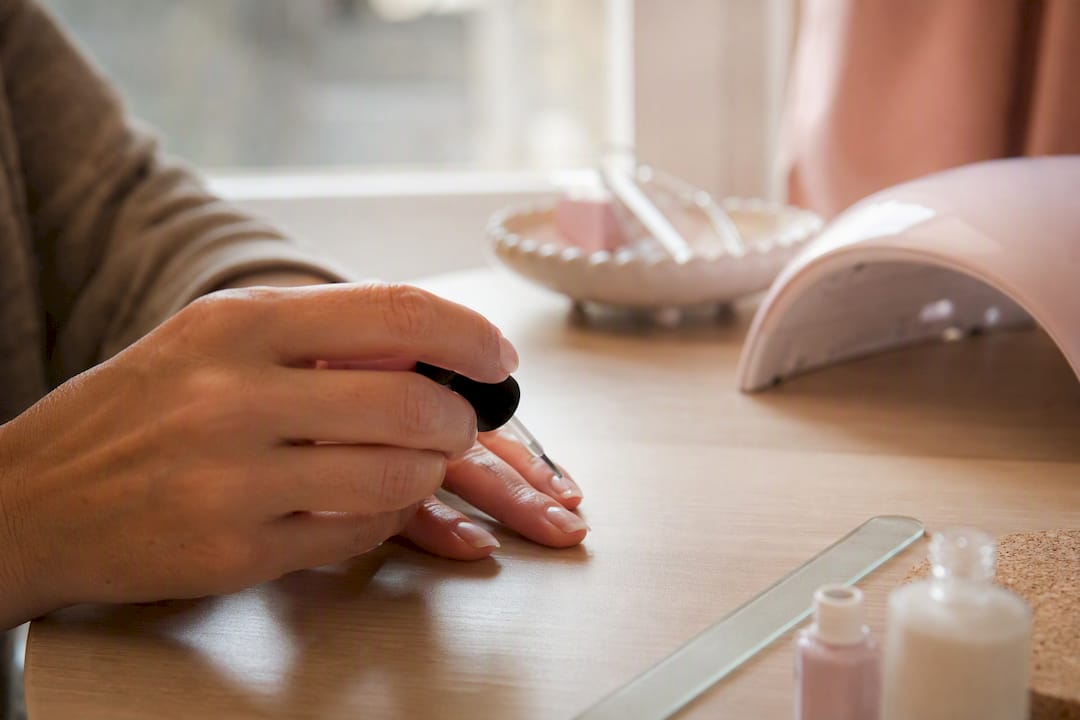 Hand die voorzichtig gellak op de nagels aanbrengt
